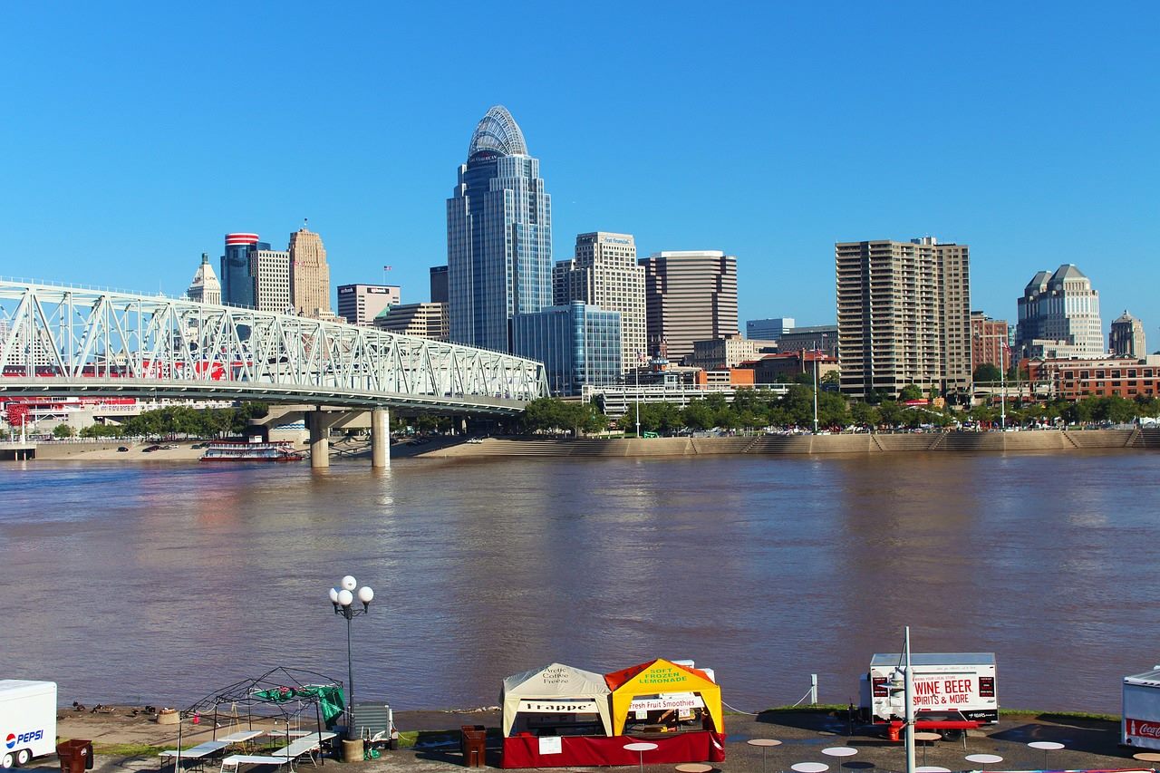 A revitalized waterfront in a northern Great Lakes city, with brick warehouses, fresh water, and green hills under a clear sky
