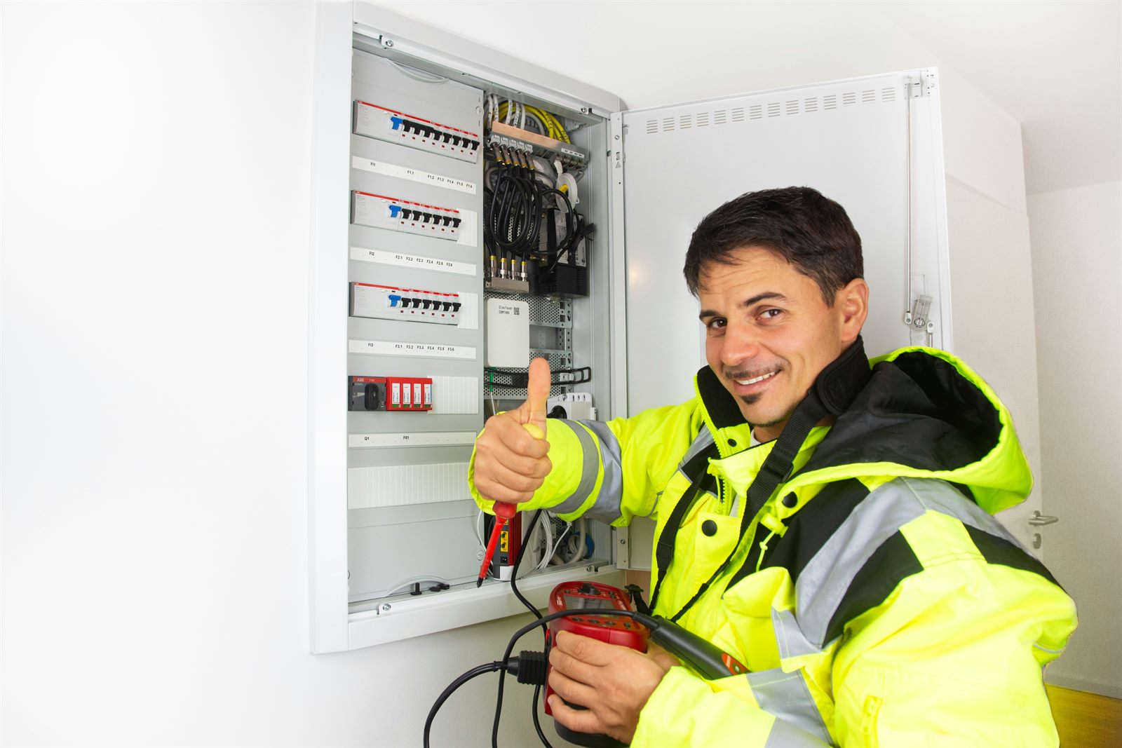 Apprentice electrician installing a heat pump system while a mentor explains the wiring diagram