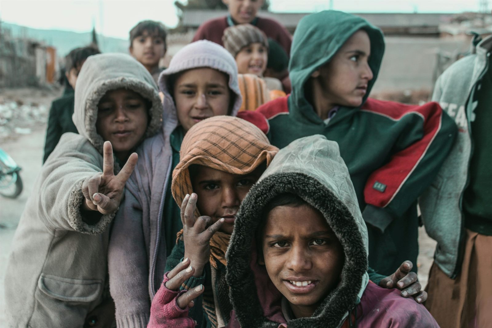 A crowded resettlement area with temporary shelters where displaced families are rebuilding on the edge of a city