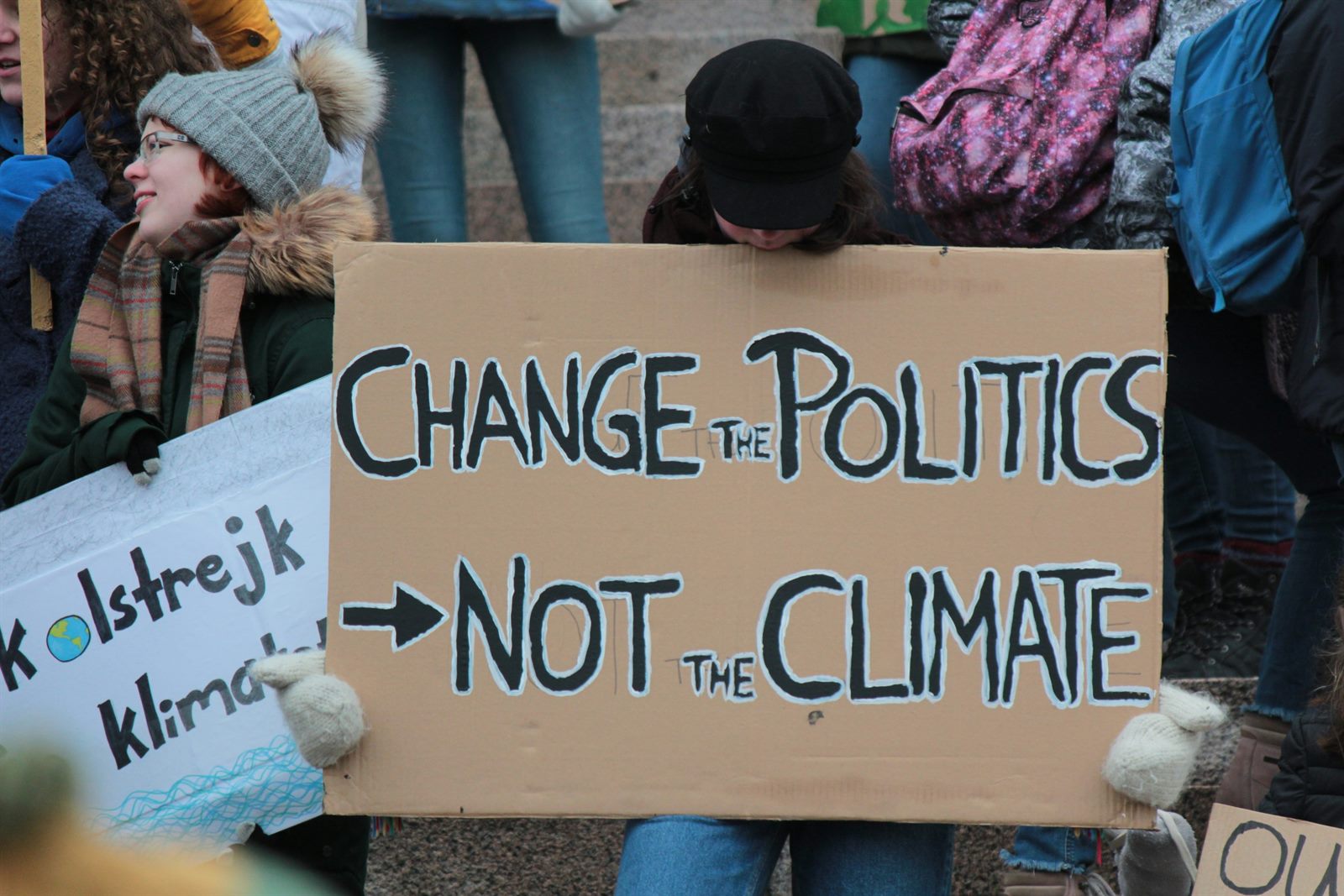 Shopper in a supermarket aisle comparing a long grocery receipt against rising price labels on the shelf