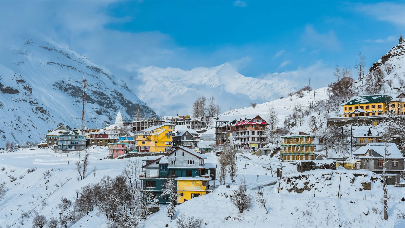 Family hiking past a converted alpine village where a former ski lift station now serves as a mountain bike hub