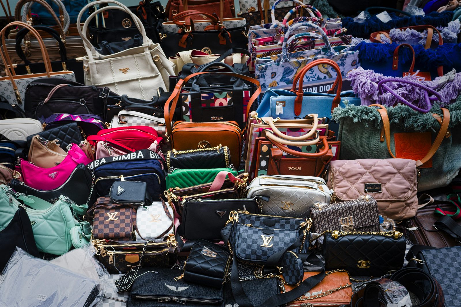 A flat lay of budget beauty and fashion products arranged to mimic high-end luxury equivalents, with price tags visible