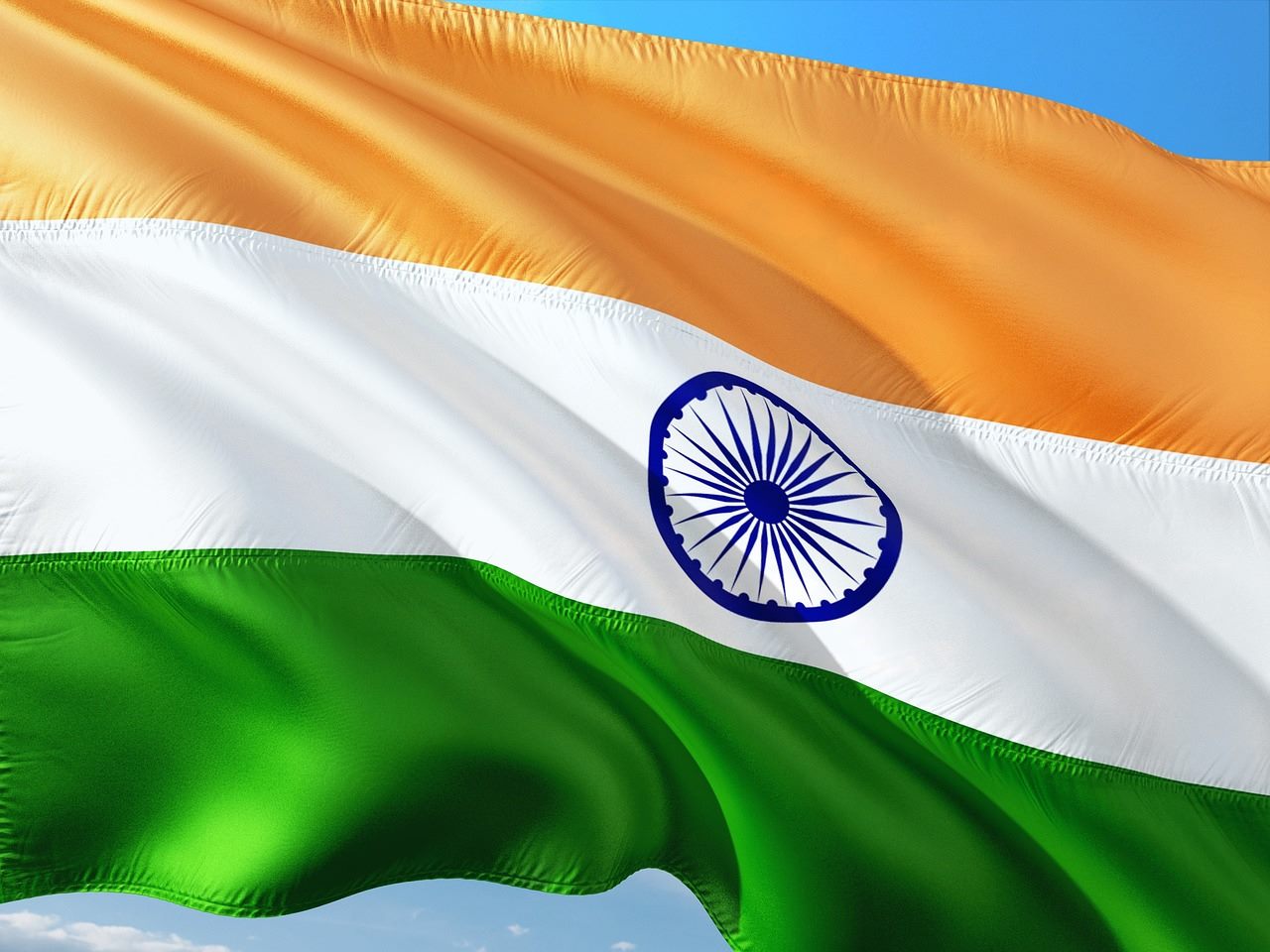 Indian national flag flying in front of a modern city skyline