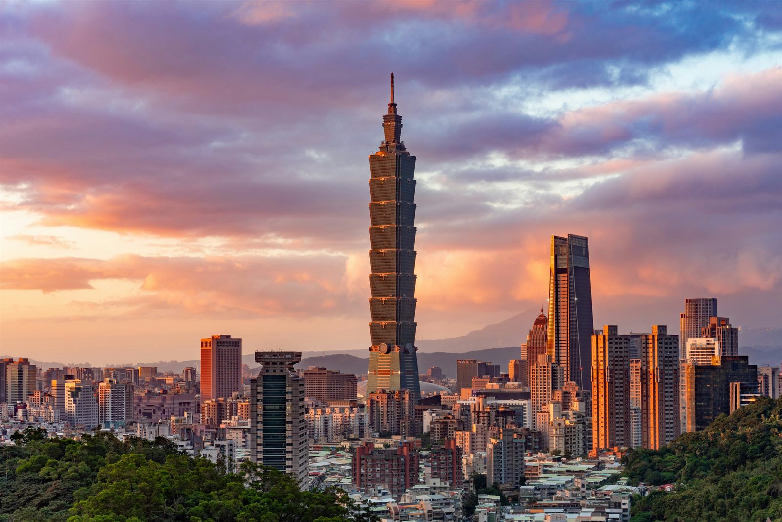 Container ships crossing the Taiwan Strait with the island's mountainous coastline visible in the distance