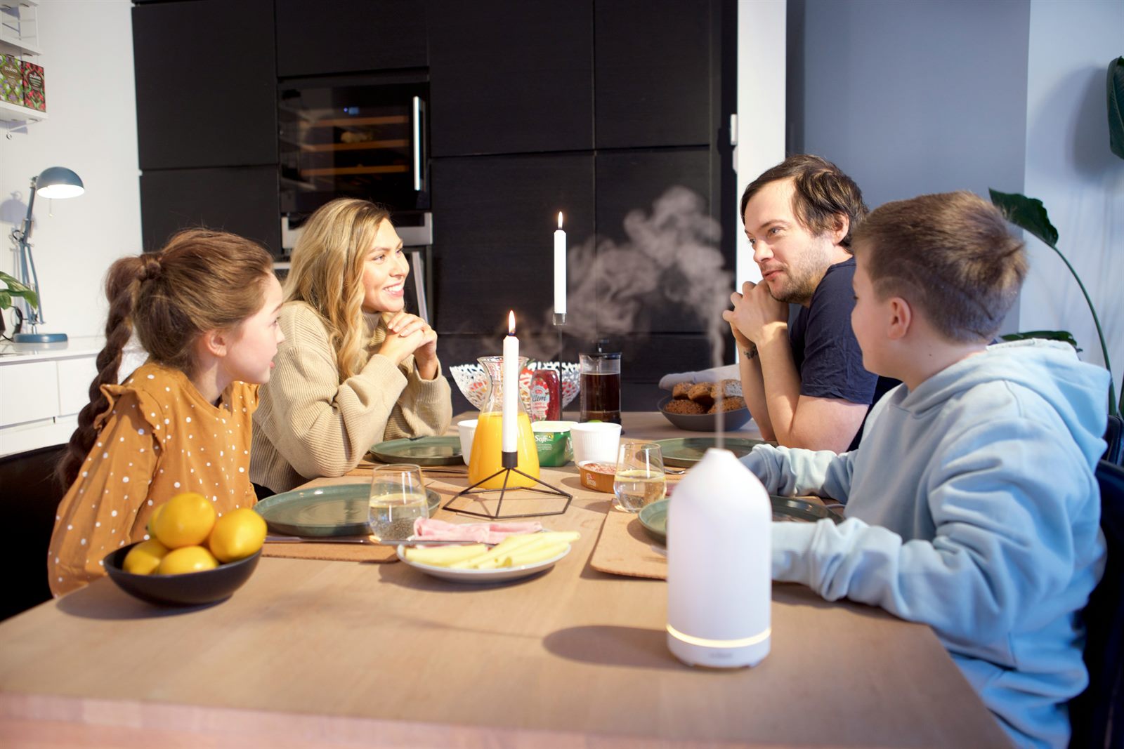 Family gathered around a dinner table sharing a meal, phones absent, conversation flowing