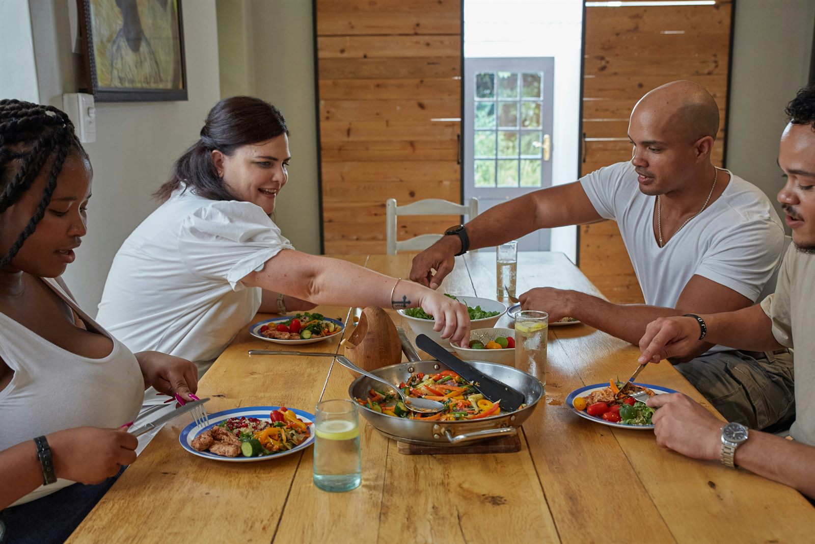 Parents and children sitting around a kitchen table sharing a simple weeknight meal
