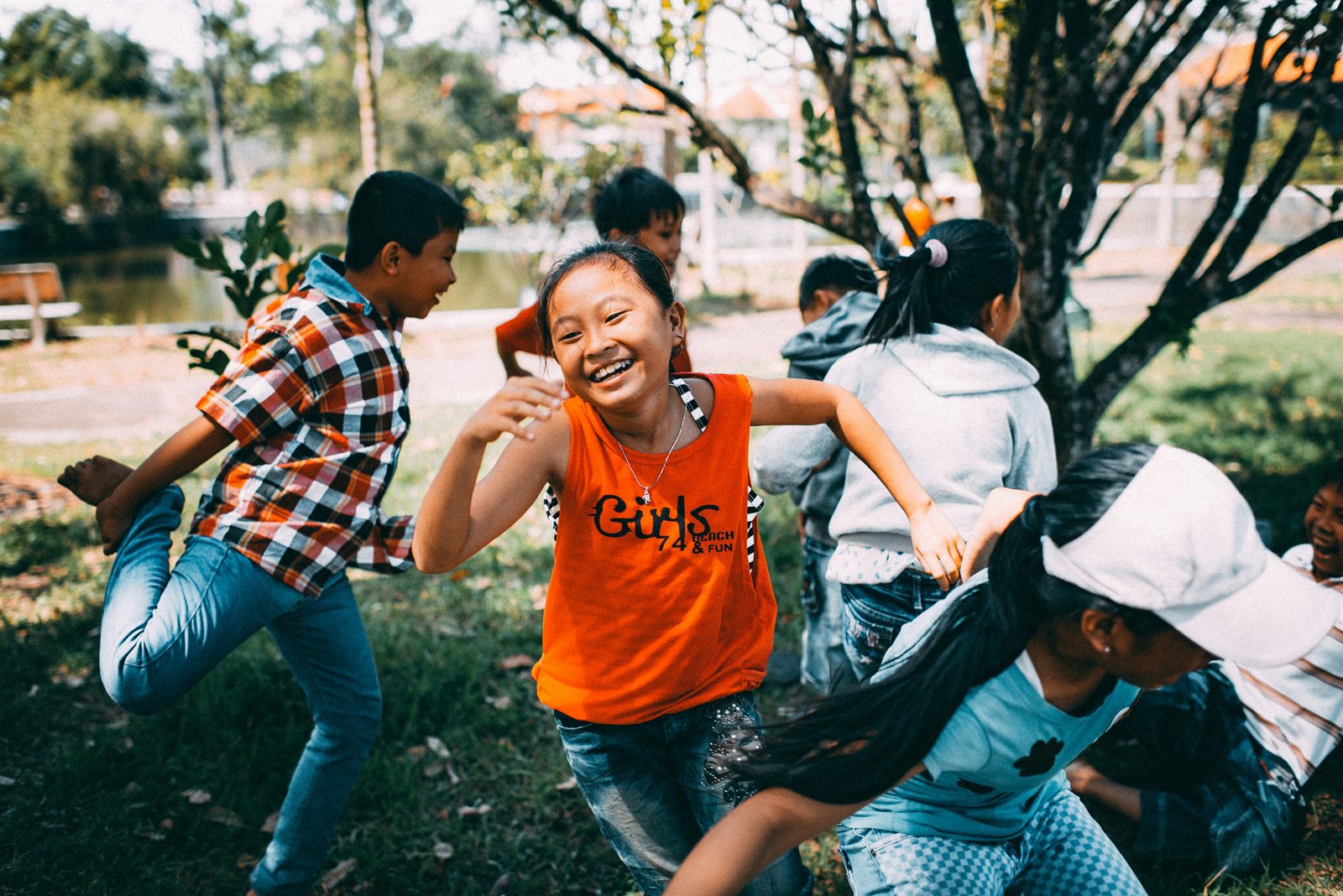 Children playing freely in a park, climbing trees and running