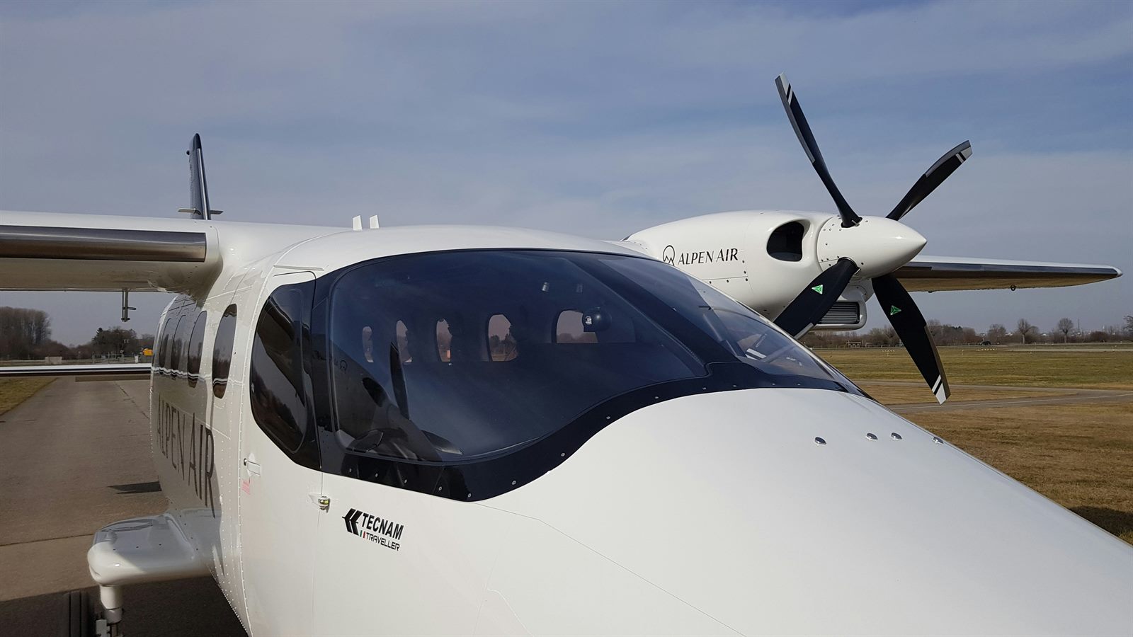 Empty cockpit of a commercial aircraft with autopilot systems engaged over clouds