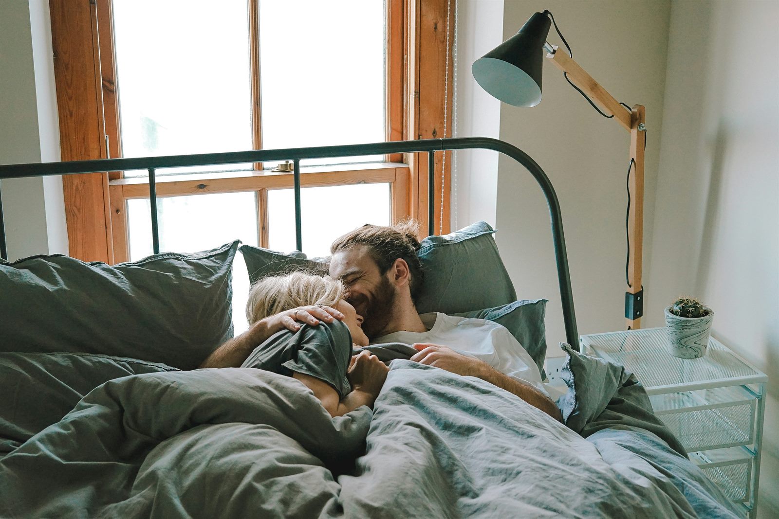 Two people sitting apart on a couch, each looking at their phones in a quiet apartment