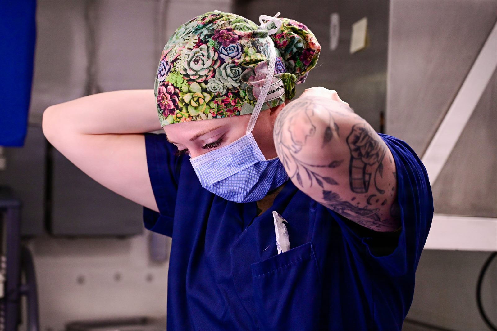 Professional with visible tattoos working confidently in a modern office