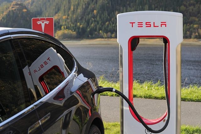 Technician installing a grid buffer battery cabinet beside a row of ultra-fast electric vehicle chargers