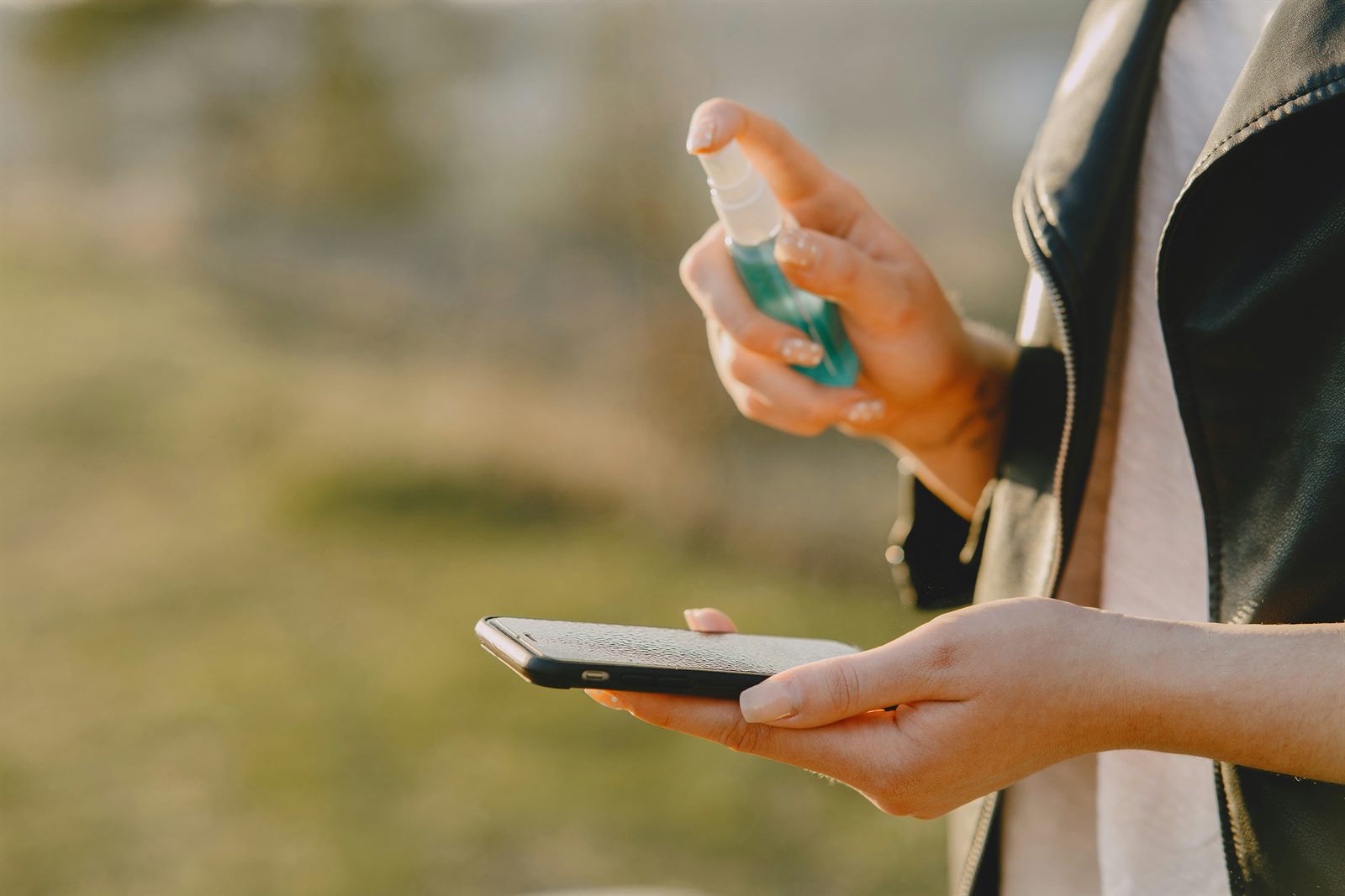 A compact consumer scent device beside a smartphone releasing a visible mist of fragrance